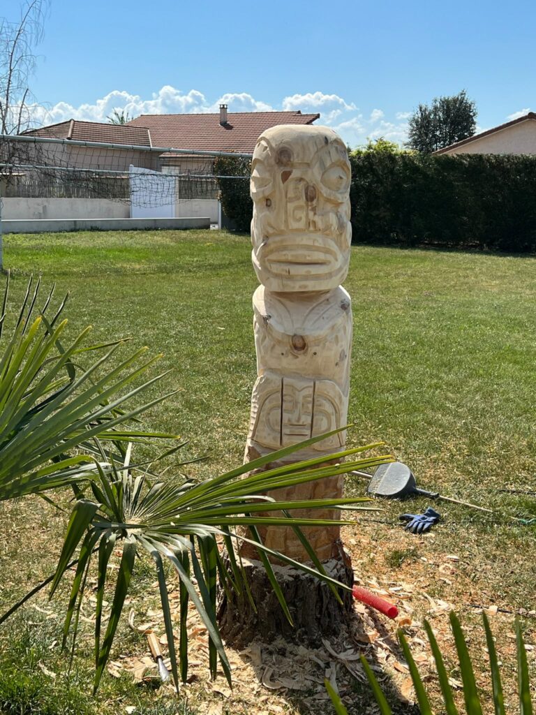 Totem sculpté directement dans la souche d un arbre, dans un jardin privé